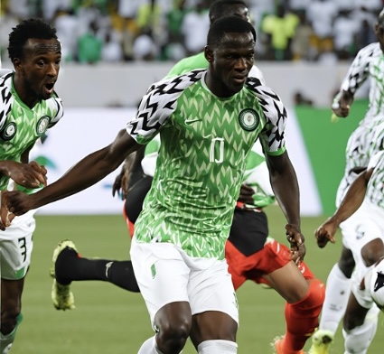 Some Super Eagles players on the pitch during an AFCON qualifier, showcasing teamwork and determination in their green and white jerseys, ahead of Nigeria vs Libya encounters.